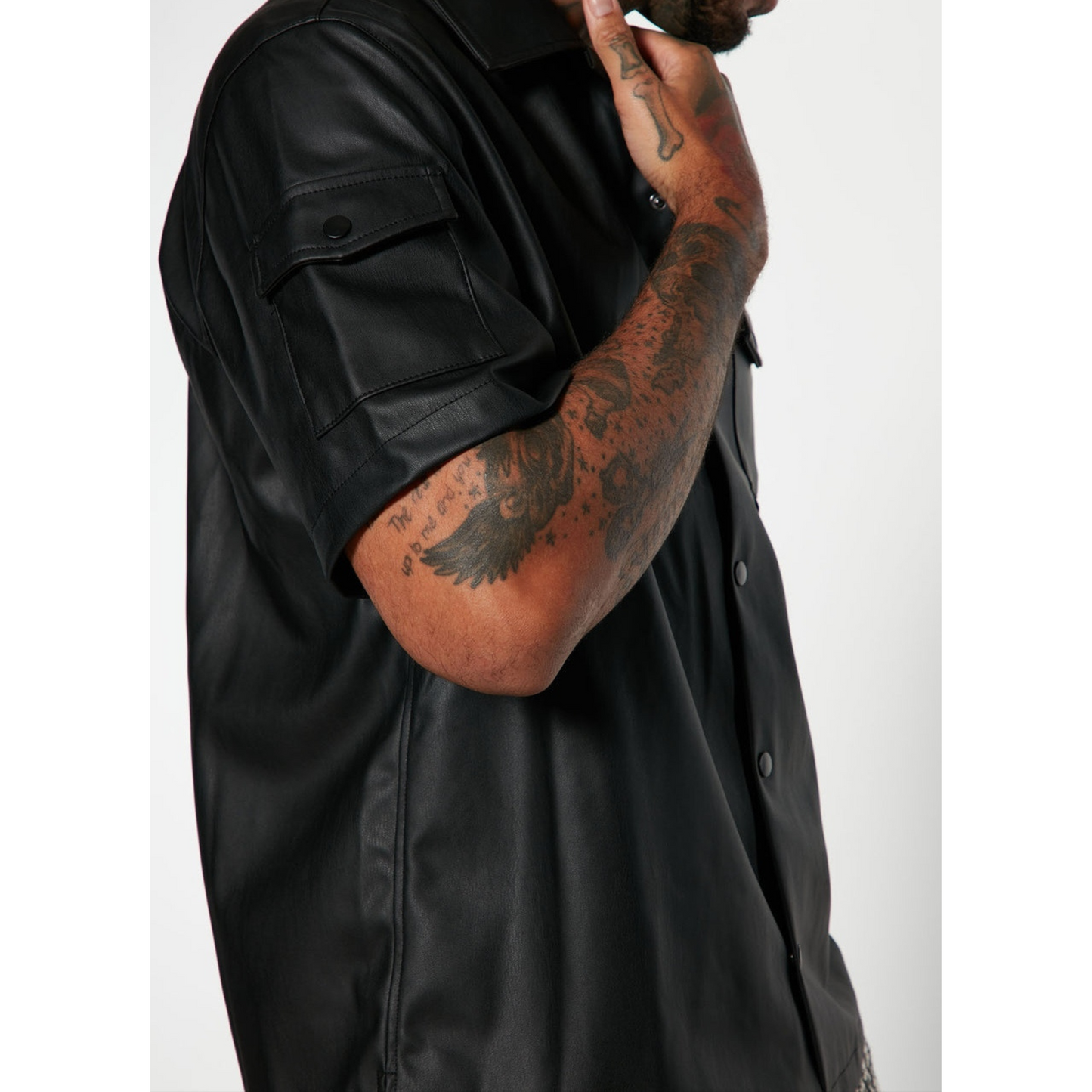 Detailed close-up of men's black genuine leather shirt, highlighting the smooth texture, fine stitching, and high-quality full-grain leather craftsmanship – Hides & Cult.