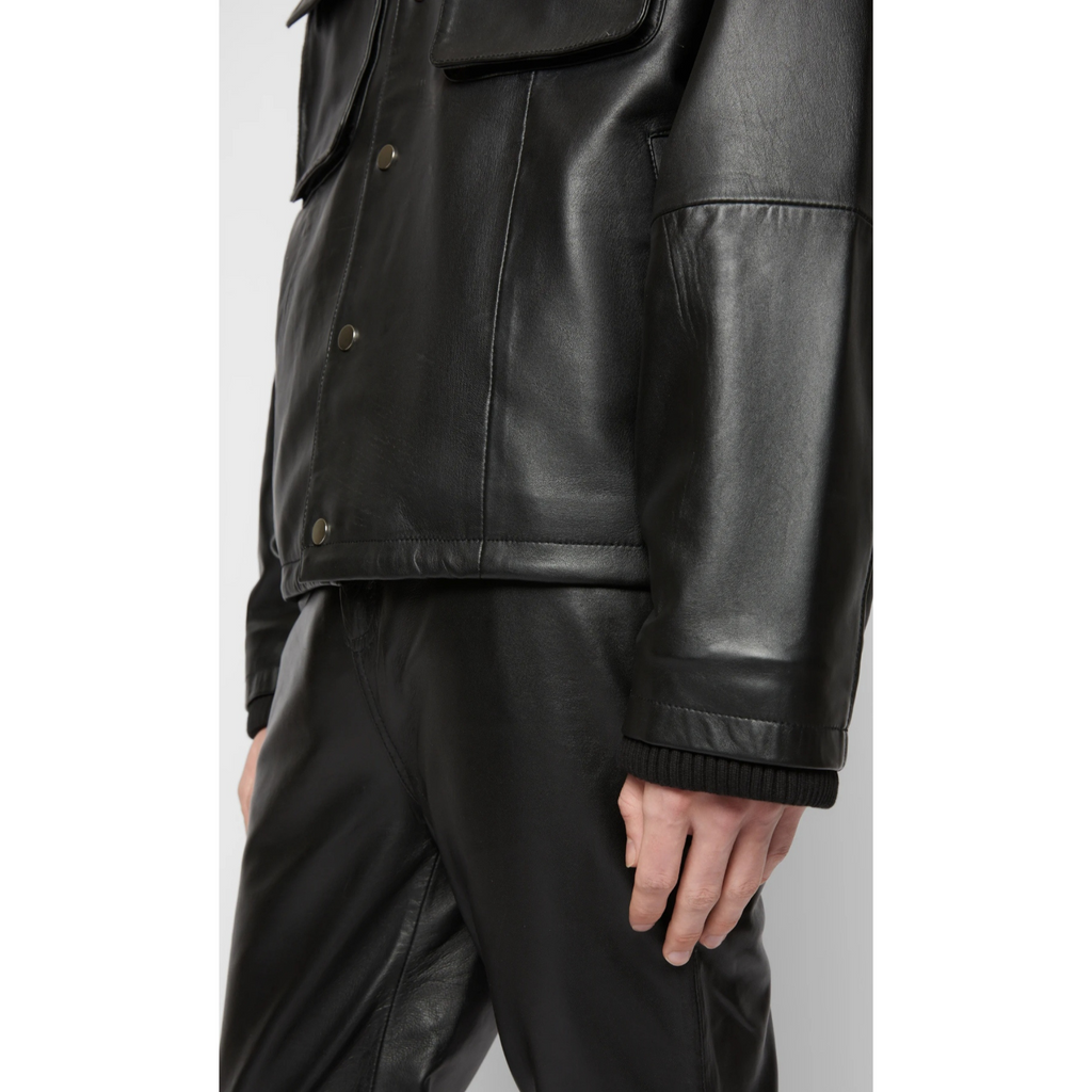 Close-up of men's black bomber style hooded genuine leather sweatshirt and leather pants, highlighting premium full-grain leather texture and detailed craftsmanship – Hides & Cult.
