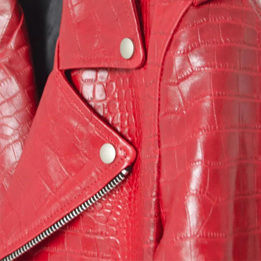 Close-up of red croc-embossed leather showing texture, stitching, and metallic zip details on biker jacket