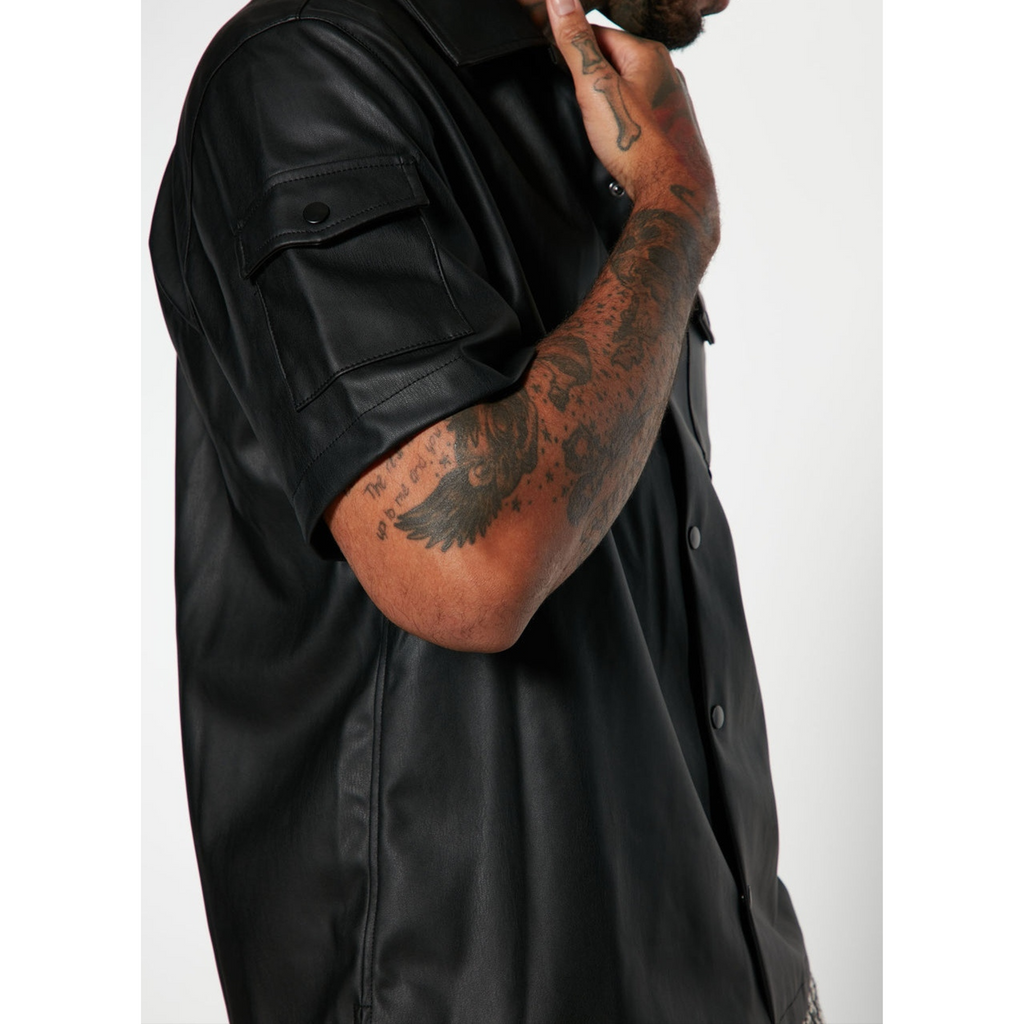 Detailed close-up of men's black genuine leather shirt, highlighting the smooth texture, fine stitching, and high-quality full-grain leather craftsmanship – Hides & Cult.