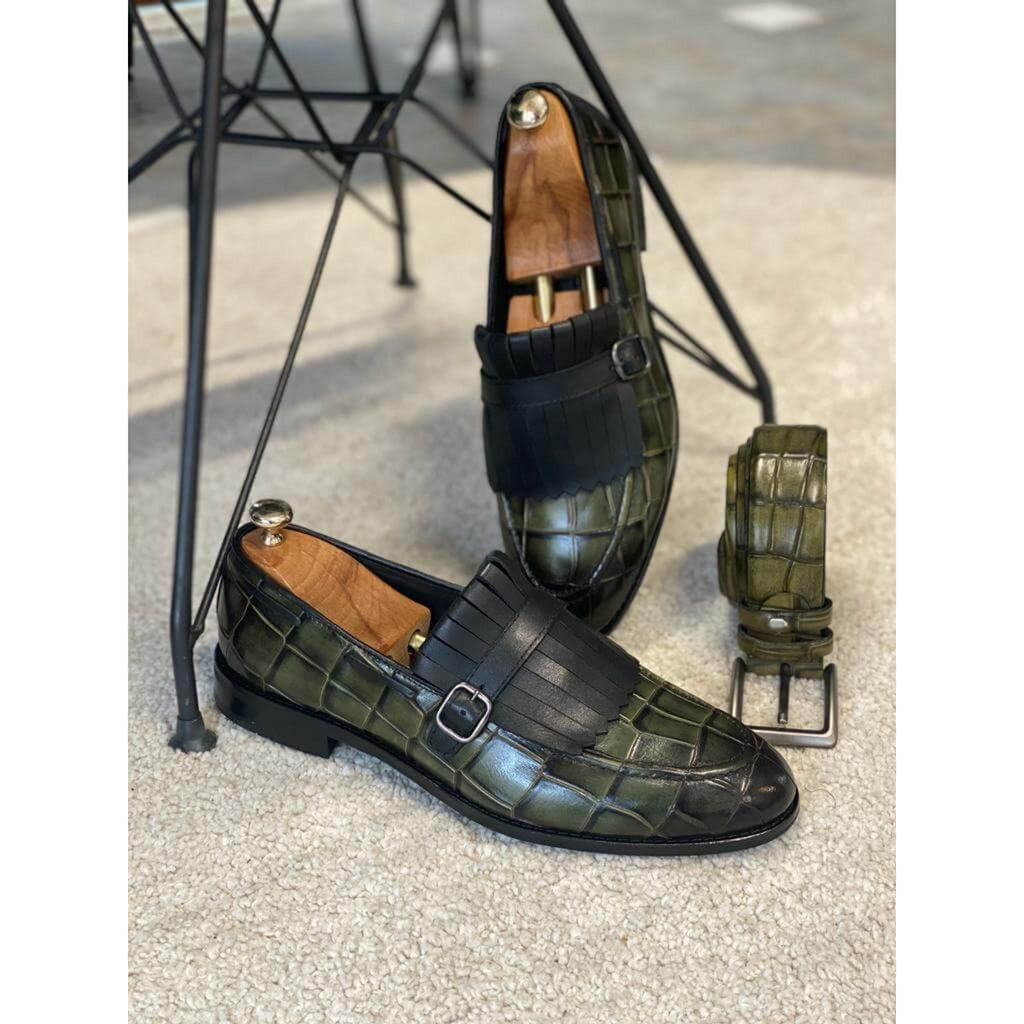 Side profile of green leather monk strap loafers with black fringe and buckle – a bold mix of craftsmanship and modern style.