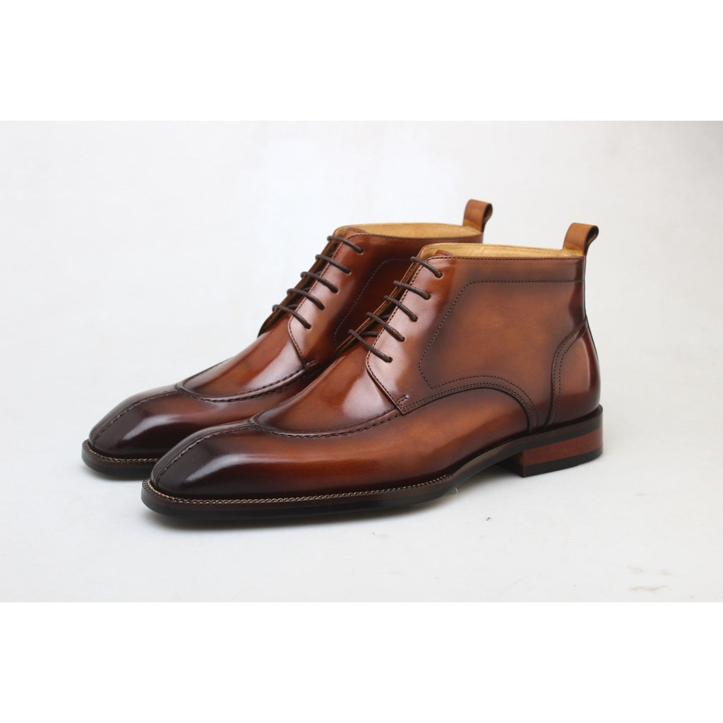 Front view of polished brown leather men’s boots – luxury handcrafted shoes with a sleek toe and high ankle support