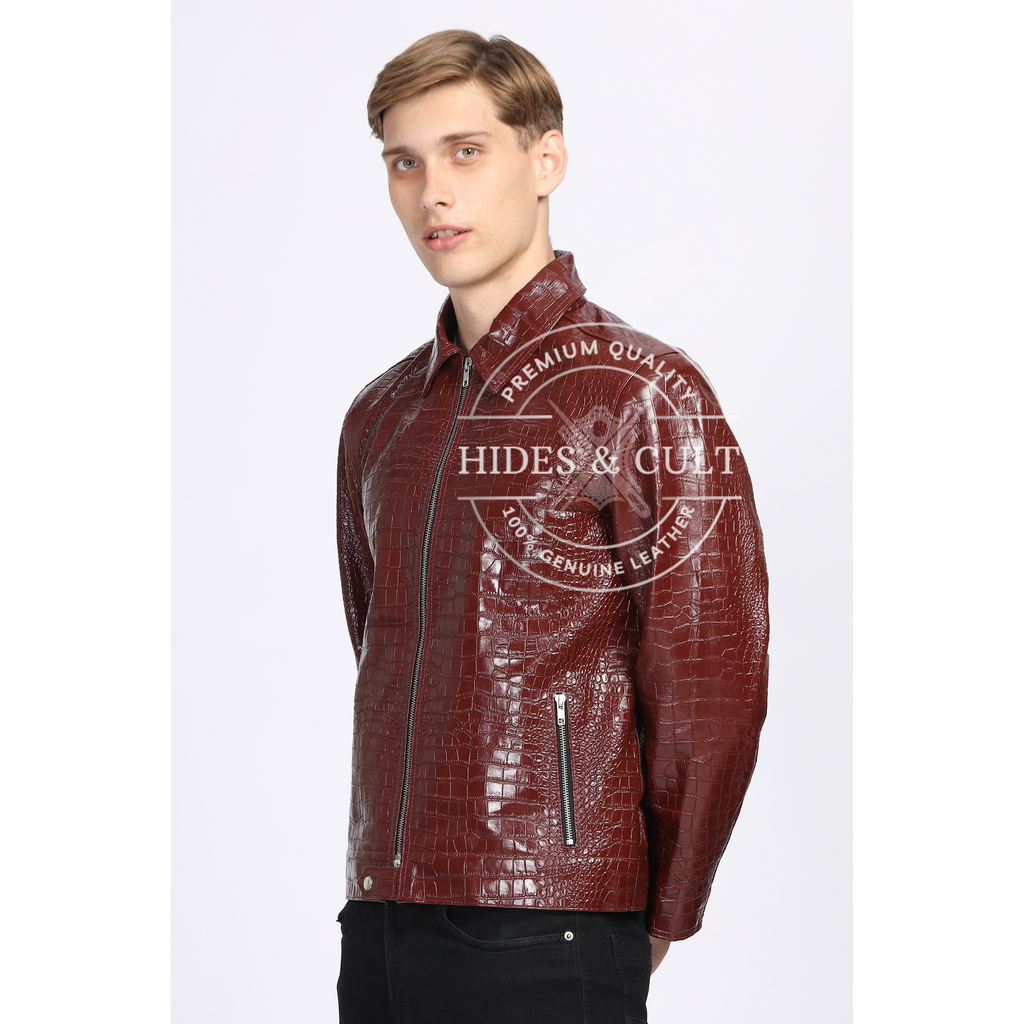 Male model wearing burgundy crocodile-textured genuine leather jacket with closed zip by Hides & Cult, front view

