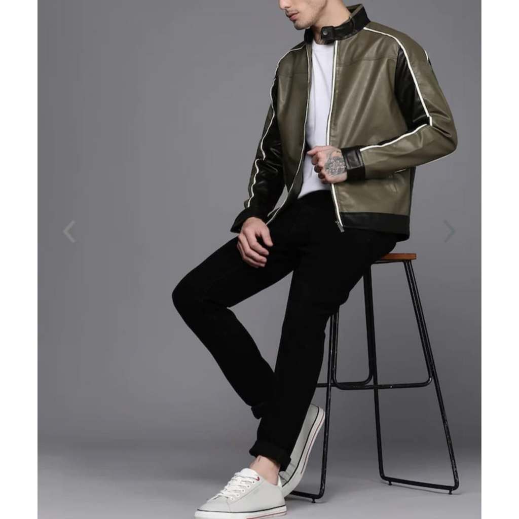 Men's olive green and black colorblock leather jacket with white stripes. Model seated, side view, showcasing the multi-tone design and tailored fit.


