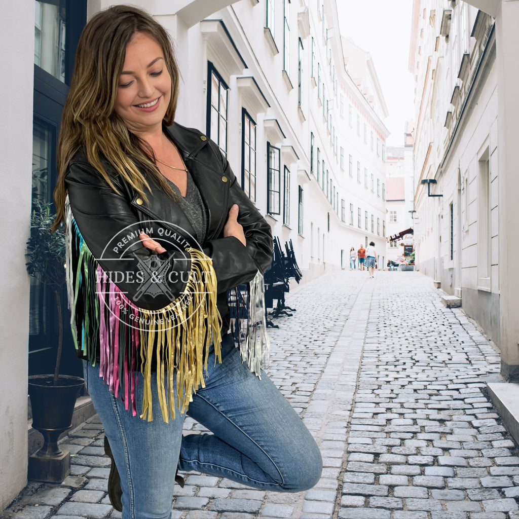 Front view of black leather jacket with rainbow foil fringes and gold hardware worn by model