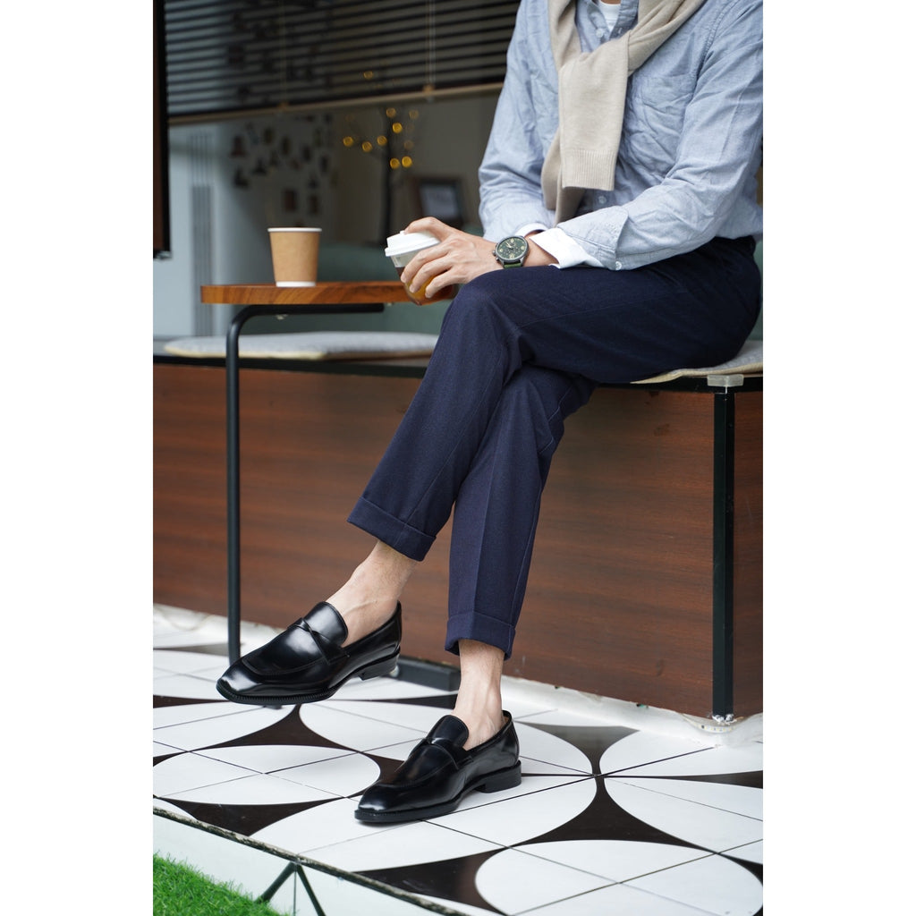 Classic black leather loafers displayed with wooden shoe trees – premium footwear for formal and office wear.