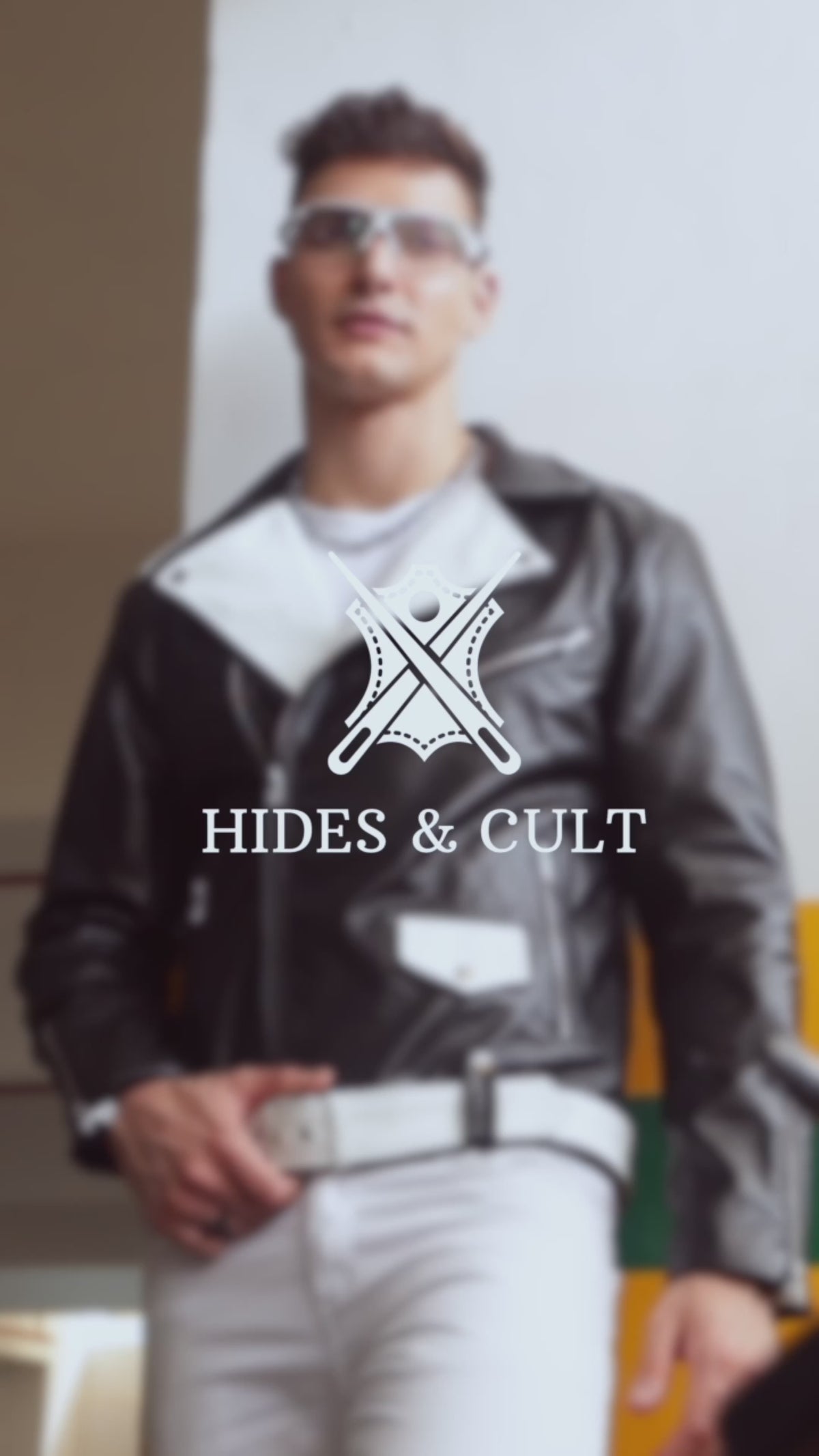 Model wearing men's black and white two tone slim fit motorcycle biker leather jacket walking and posing in urban setting full-body style showcase video